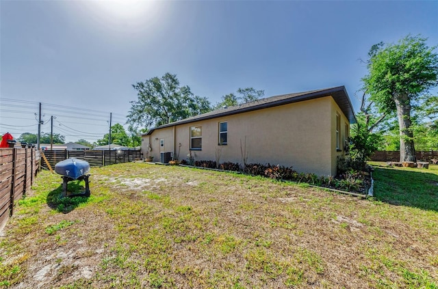 12923 Colony Rd, Hudson, FL 34669 - back of property featuring fence, central air condition unit, stucco siding, and a yard