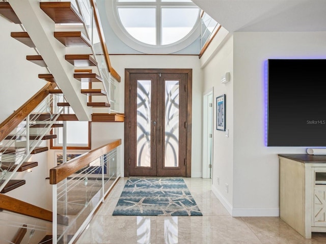 entryway featuring plenty of natural light, french doors, and stairs