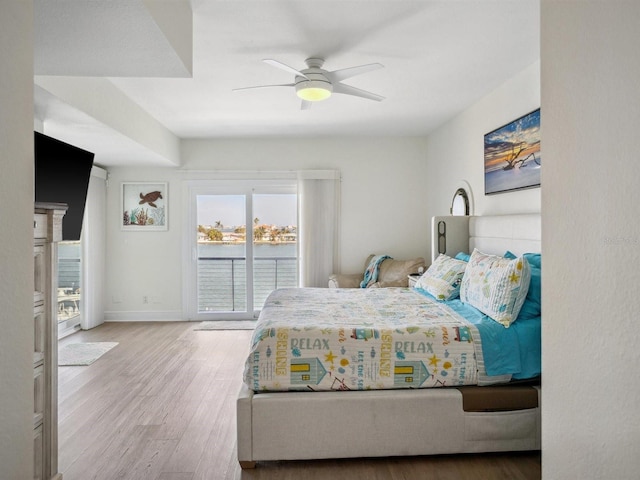bedroom featuring access to outside, baseboards, ceiling fan, and wood finished floors