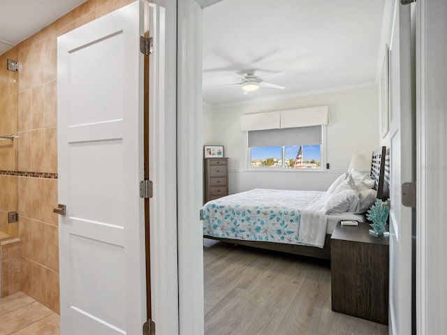 bedroom with ornamental molding, ceiling fan, and wood finished floors