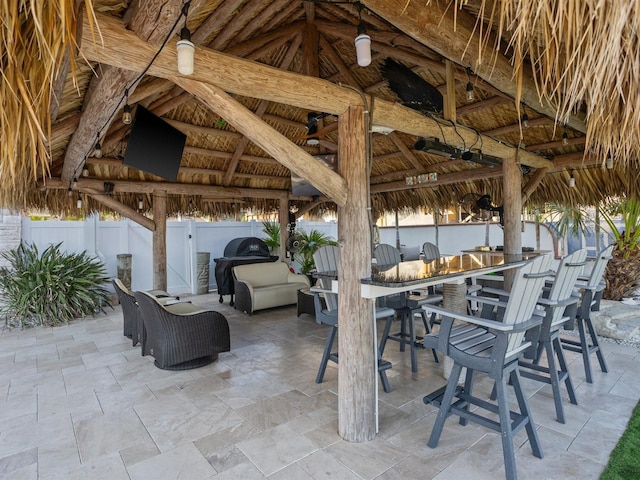 view of patio / terrace featuring a gazebo, a fenced backyard, and outdoor dry bar
