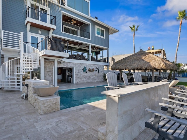 outdoor pool with stairway, a gazebo, a ceiling fan, and outdoor dry bar