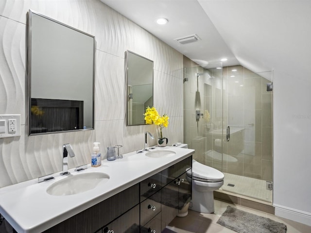 full bathroom with double vanity, a sink, a stall shower, and toilet
