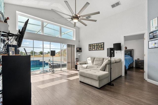 living room featuring visible vents, ceiling fan, wood finished floors, and high vaulted ceiling