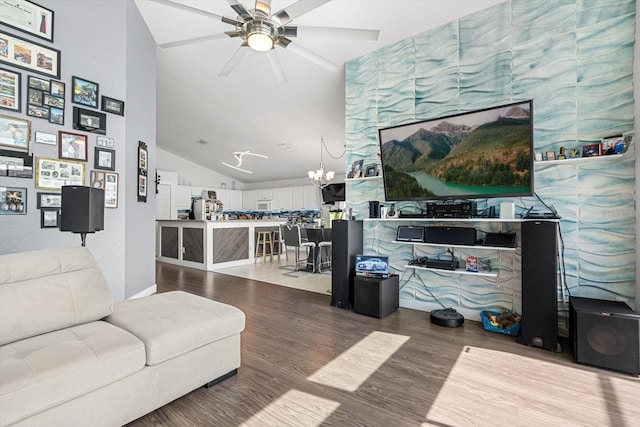 living area featuring lofted ceiling, wood finished floors, and ceiling fan with notable chandelier
