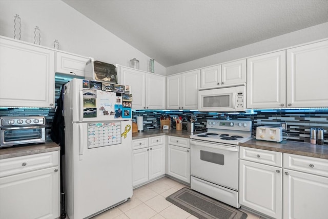 kitchen featuring a toaster, dark countertops, white appliances, backsplash, and vaulted ceiling