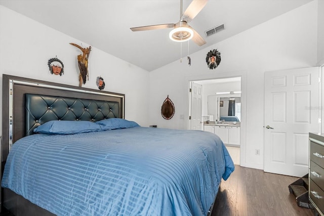 bedroom with visible vents, ensuite bathroom, dark wood-style floors, a ceiling fan, and vaulted ceiling