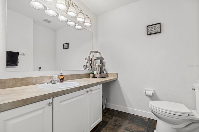 bathroom with stone finish floor, visible vents, vanity, baseboards, and toilet