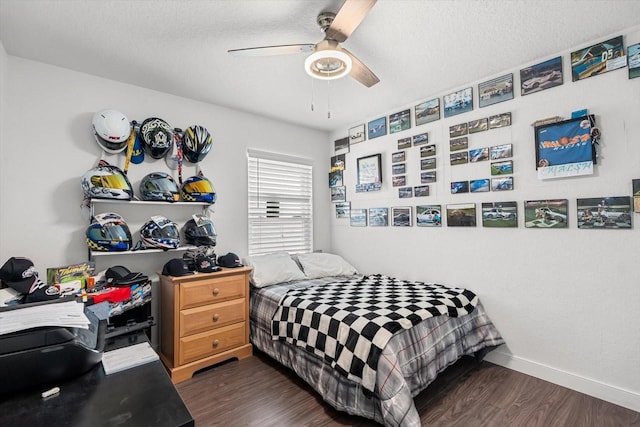 bedroom with dark wood-style flooring, a ceiling fan, baseboards, and a textured ceiling