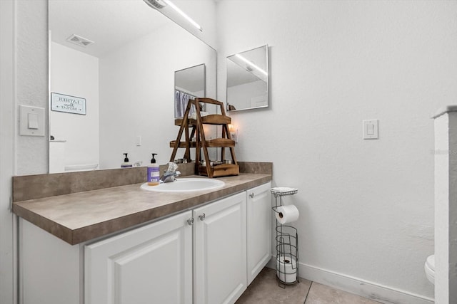 bathroom featuring visible vents, tile patterned flooring, vanity, baseboards, and toilet
