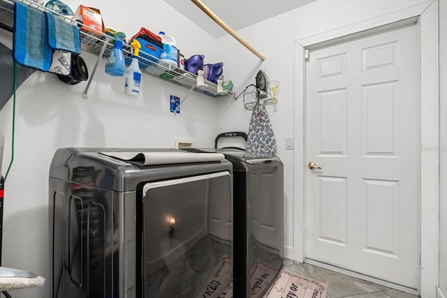 washroom with light tile patterned floors, laundry area, and washer and clothes dryer