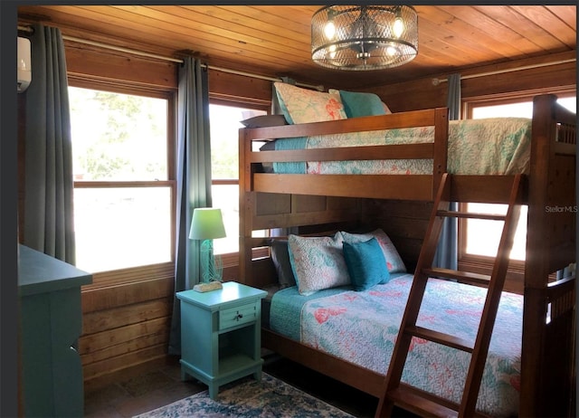 bedroom featuring wooden ceiling and wood walls
