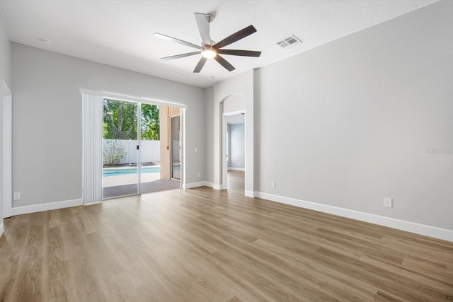 unfurnished room featuring baseboards, ceiling fan, light wood finished floors, and visible vents