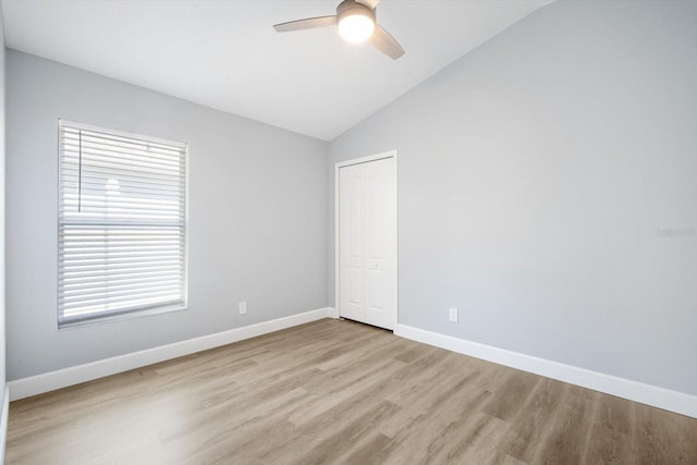 unfurnished room with baseboards, ceiling fan, wood finished floors, and lofted ceiling