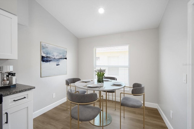 dining area with baseboards, recessed lighting, wood finished floors, and vaulted ceiling