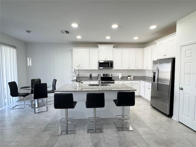 kitchen featuring visible vents, a kitchen island with sink, recessed lighting, a sink, and appliances with stainless steel finishes