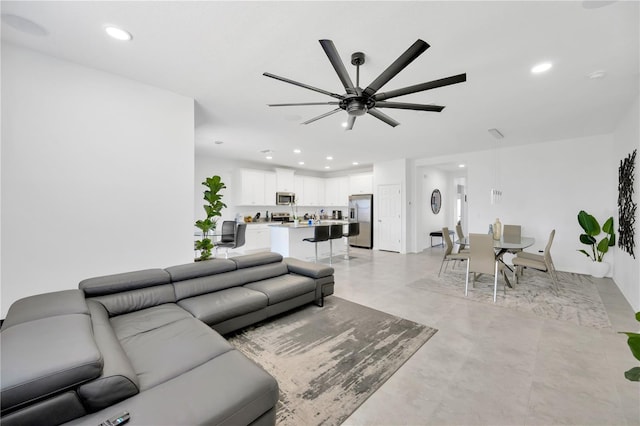 living room featuring a ceiling fan, recessed lighting, and finished concrete floors