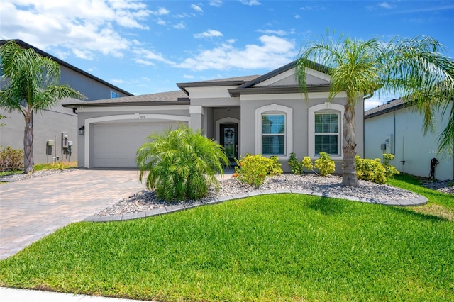 view of front of property featuring an attached garage, decorative driveway, and a front lawn