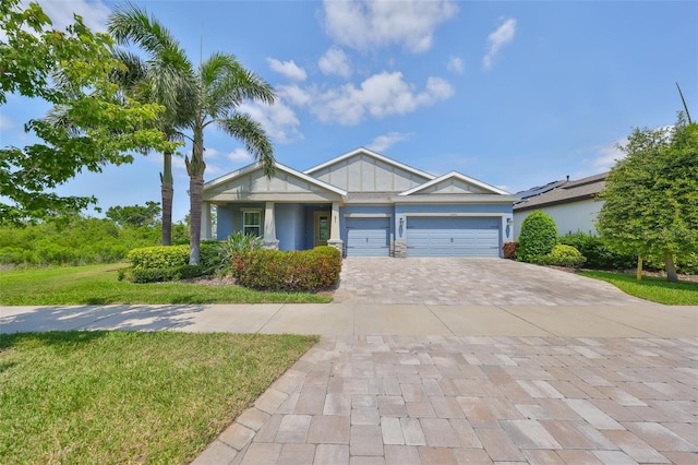view of front of house with a garage, decorative driveway, stucco siding, and a front yard