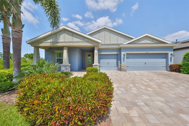 view of front of house with decorative driveway, a garage, and stucco siding