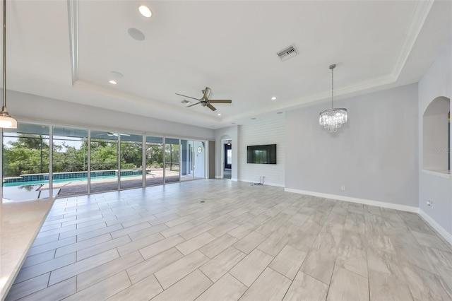 unfurnished living room featuring visible vents, recessed lighting, a raised ceiling, and ceiling fan with notable chandelier