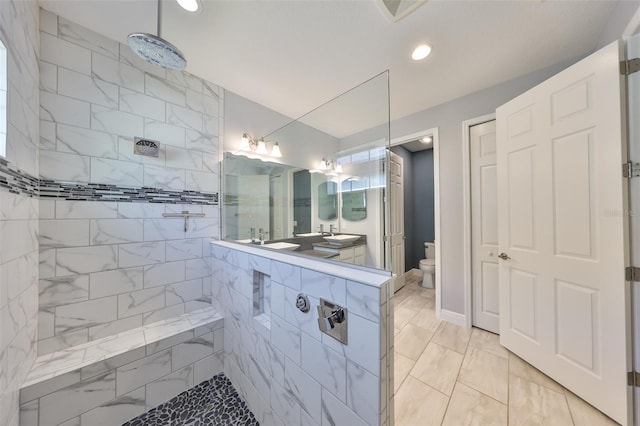 bathroom featuring a tile shower, a sink, toilet, marble finish floor, and recessed lighting