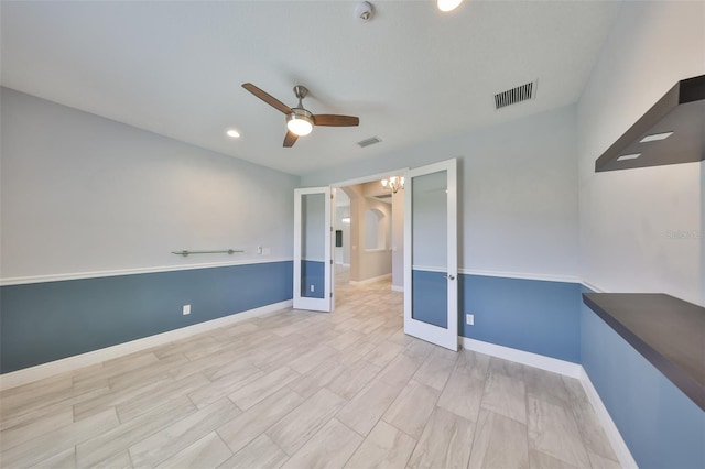 spare room with visible vents, baseboards, ceiling fan, and wood finished floors