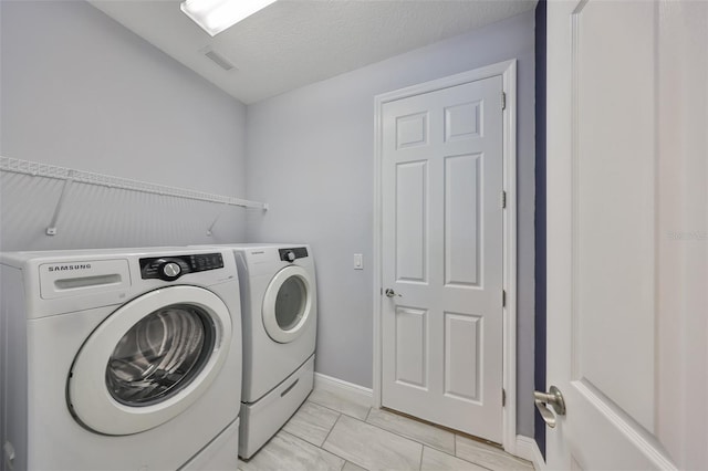 laundry area with visible vents, laundry area, marble finish floor, and washer and clothes dryer