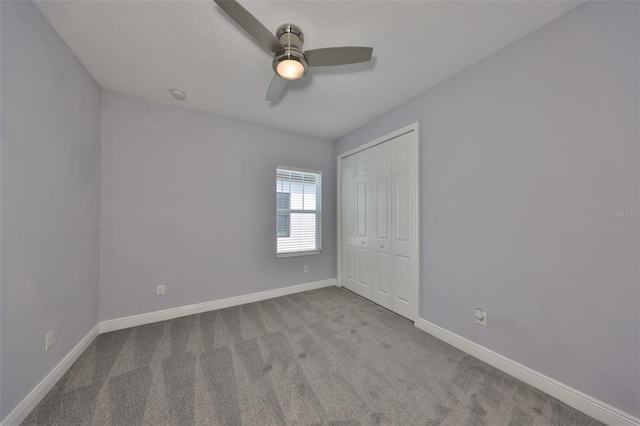 unfurnished bedroom with a closet, baseboards, a ceiling fan, and carpet flooring