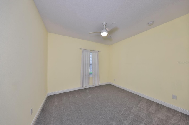 empty room featuring baseboards, ceiling fan, and dark colored carpet