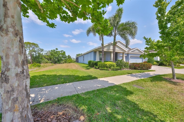 view of front of house featuring an attached garage, driveway, and a front yard