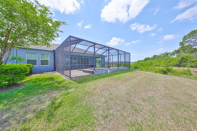 rear view of house with stucco siding, an outdoor pool, a patio area, a lawn, and a lanai