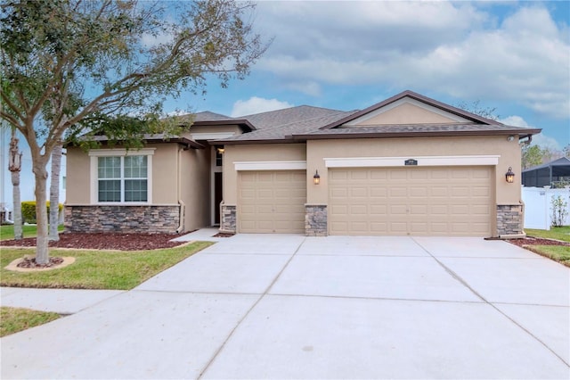 view of front of home featuring stucco siding, stone siding, a garage, driveway, and fence