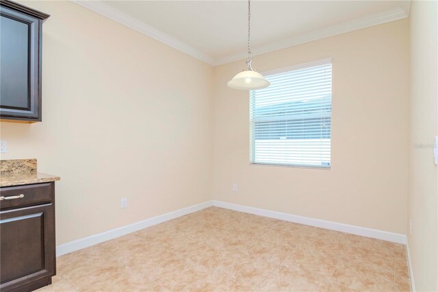 unfurnished dining area featuring ornamental molding and baseboards