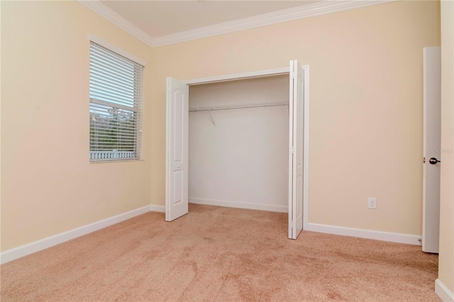 unfurnished bedroom featuring ornamental molding, carpet, baseboards, and a closet