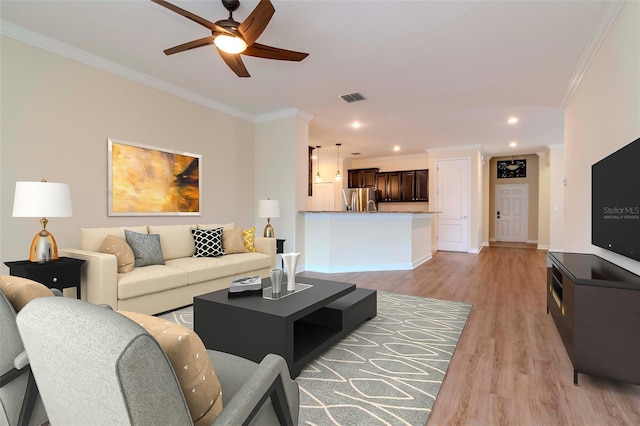 living room with ornamental molding, light wood finished floors, ceiling fan, baseboards, and recessed lighting