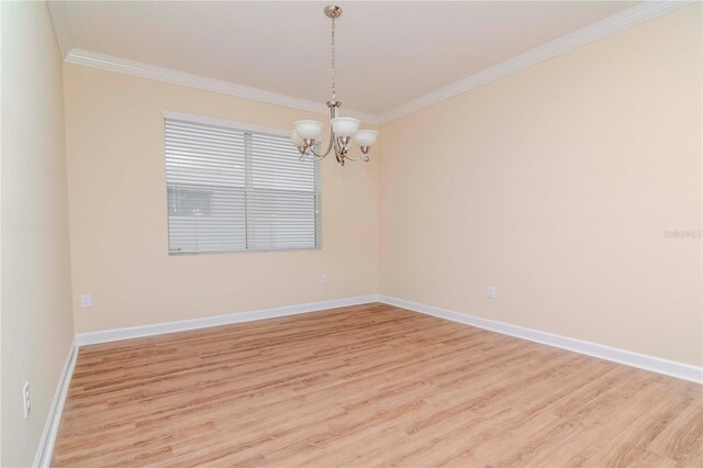 empty room with crown molding, light wood finished floors, a chandelier, and baseboards