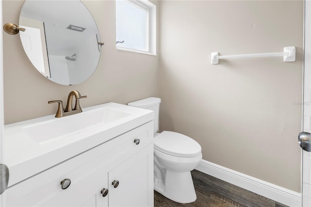 bathroom featuring vanity, baseboards, toilet, and wood finished floors