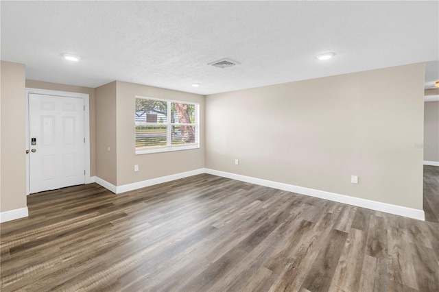 spare room featuring recessed lighting, baseboards, visible vents, and wood finished floors