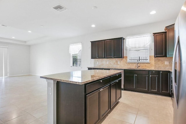 9309 Tradewater Oaks Ct, Riverview, FL 33578 - kitchen with a center island, backsplash, plenty of natural light, light tile patterned floors, and recessed lighting