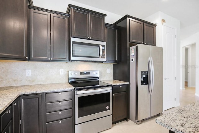 9309 Tradewater Oaks Ct, Riverview, FL 33578 - kitchen with appliances with stainless steel finishes, backsplash, dark brown cabinetry, and light stone counters