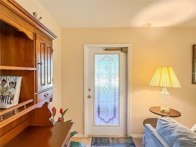 foyer with a textured ceiling and baseboards