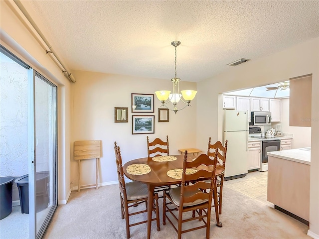 dining space with visible vents, a textured ceiling, ceiling fan with notable chandelier, and light carpet