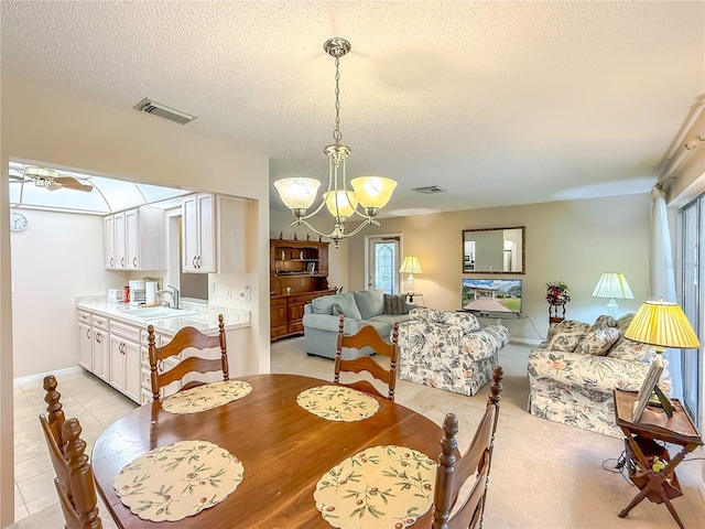 dining room featuring baseboards, visible vents, a textured ceiling, and a notable chandelier
