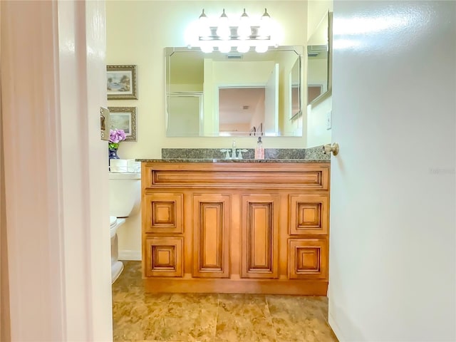 bathroom with vanity, a shower with shower door, and toilet