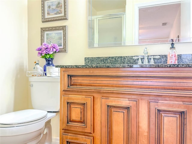 bathroom with an enclosed shower, toilet, visible vents, and vanity