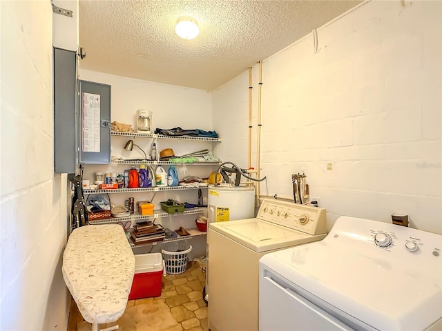 laundry area featuring laundry area, independent washer and dryer, a textured ceiling, water heater, and concrete block wall