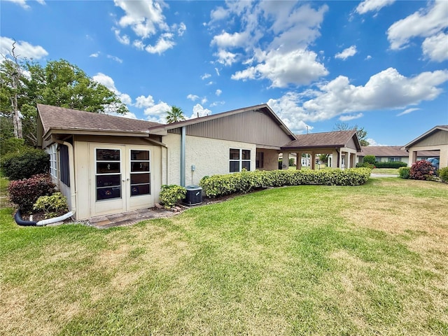 back of property featuring a yard and stucco siding
