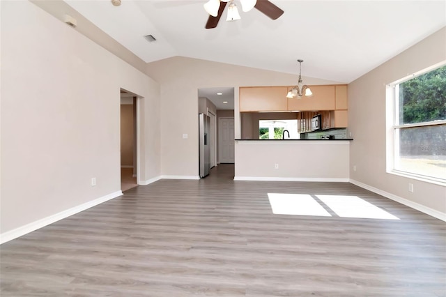 8561 Deer Chase Dr, Riverview, FL 33578 - unfurnished living room featuring vaulted ceiling, a sink, ceiling fan with notable chandelier, and wood finished floors