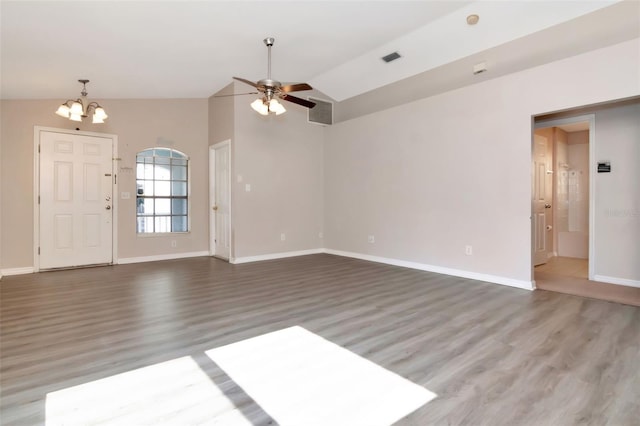 8561 Deer Chase Dr, Riverview, FL 33578 - unfurnished living room featuring vaulted ceiling, baseboards, visible vents, ceiling fan with notable chandelier, and wood finished floors